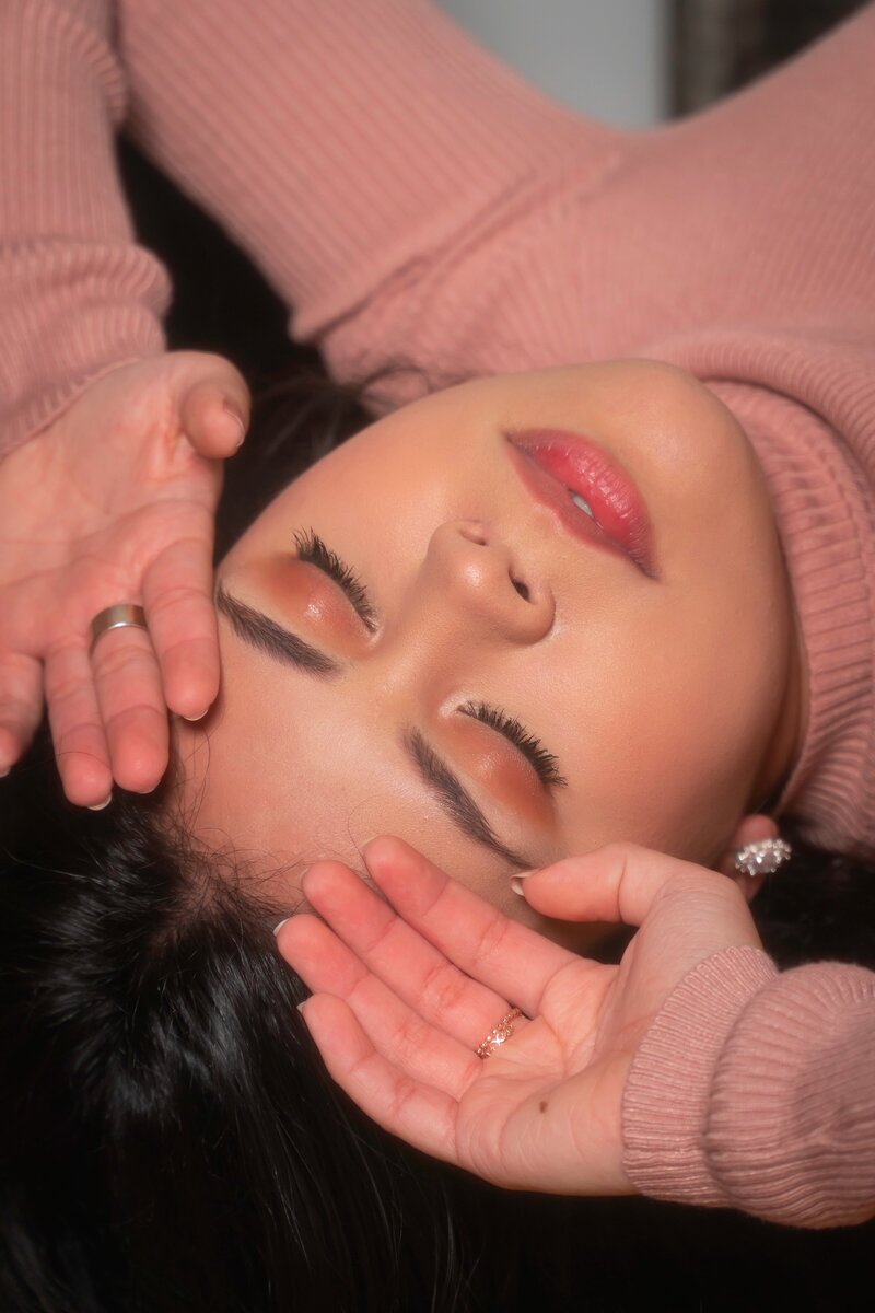 woman posing with her pink sweater and natural makeup look