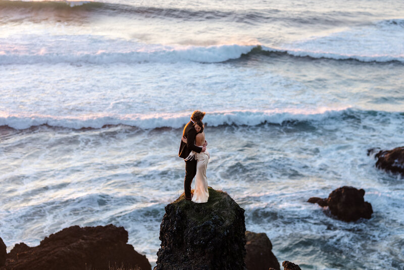 couple taking wedding photos against the cliff and water near the oregon coact Oregon Coast Elopement and Wedding Photographer