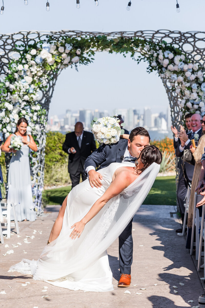 bride and groom walking on the beach at their Catamaran Resort San Diego wedding