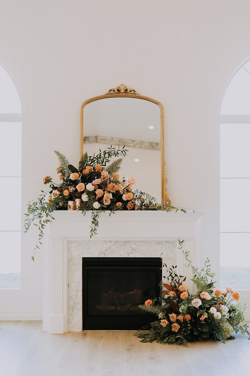 Orange boho floral arrangements on fireplace