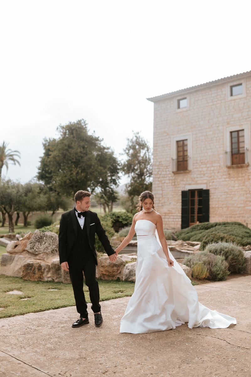 Modern wedding couple walking hand in hand outside Finca Morneta in Mallorca Spain
