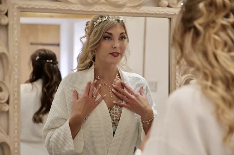 Happy bride looking at makeup and hair in mirror