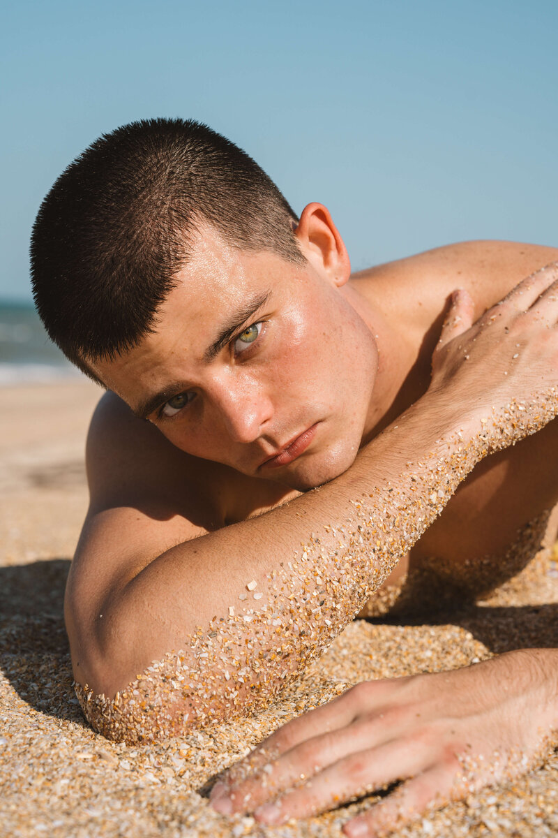 portrait of man laying on beach