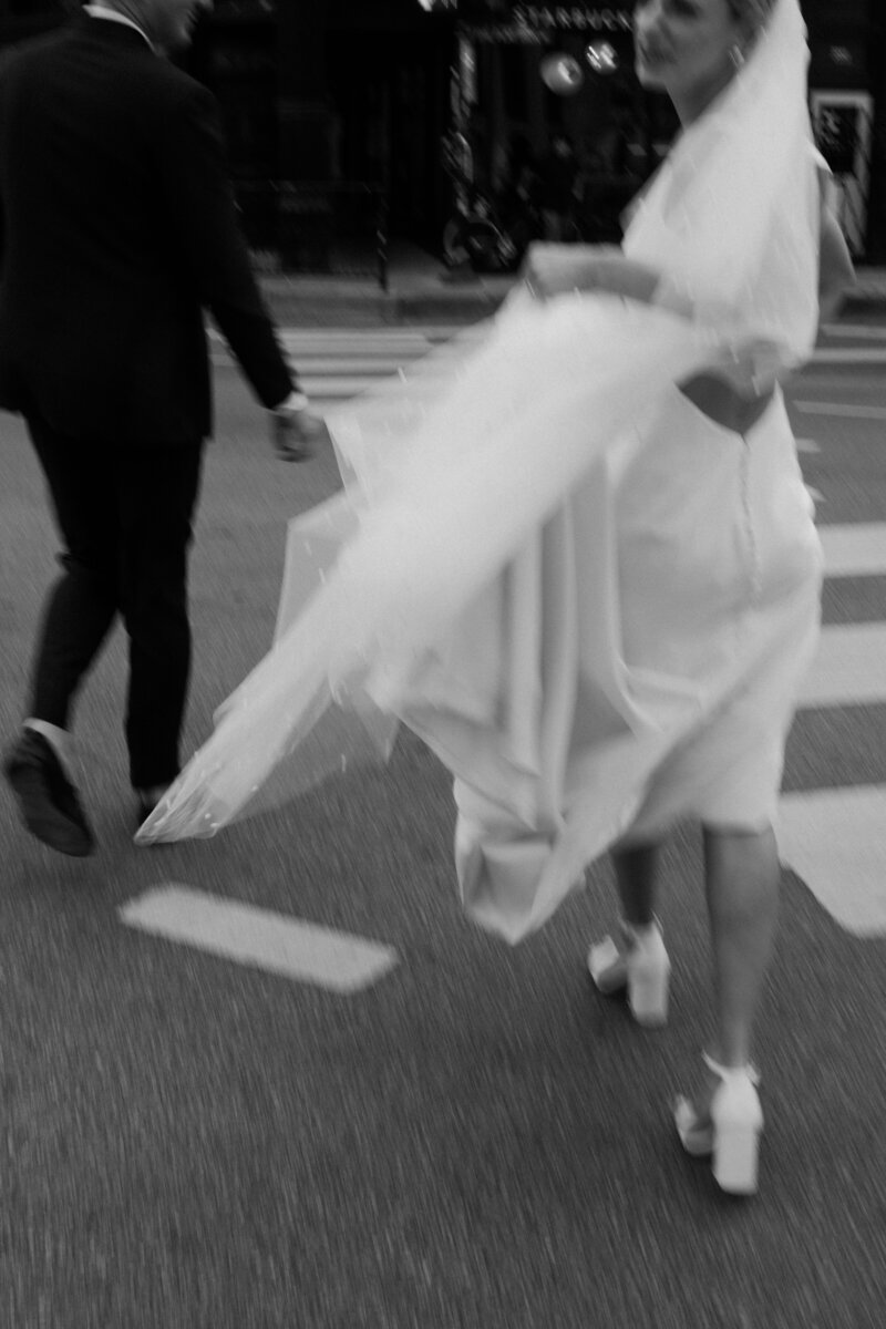 Bride and groom cross the street