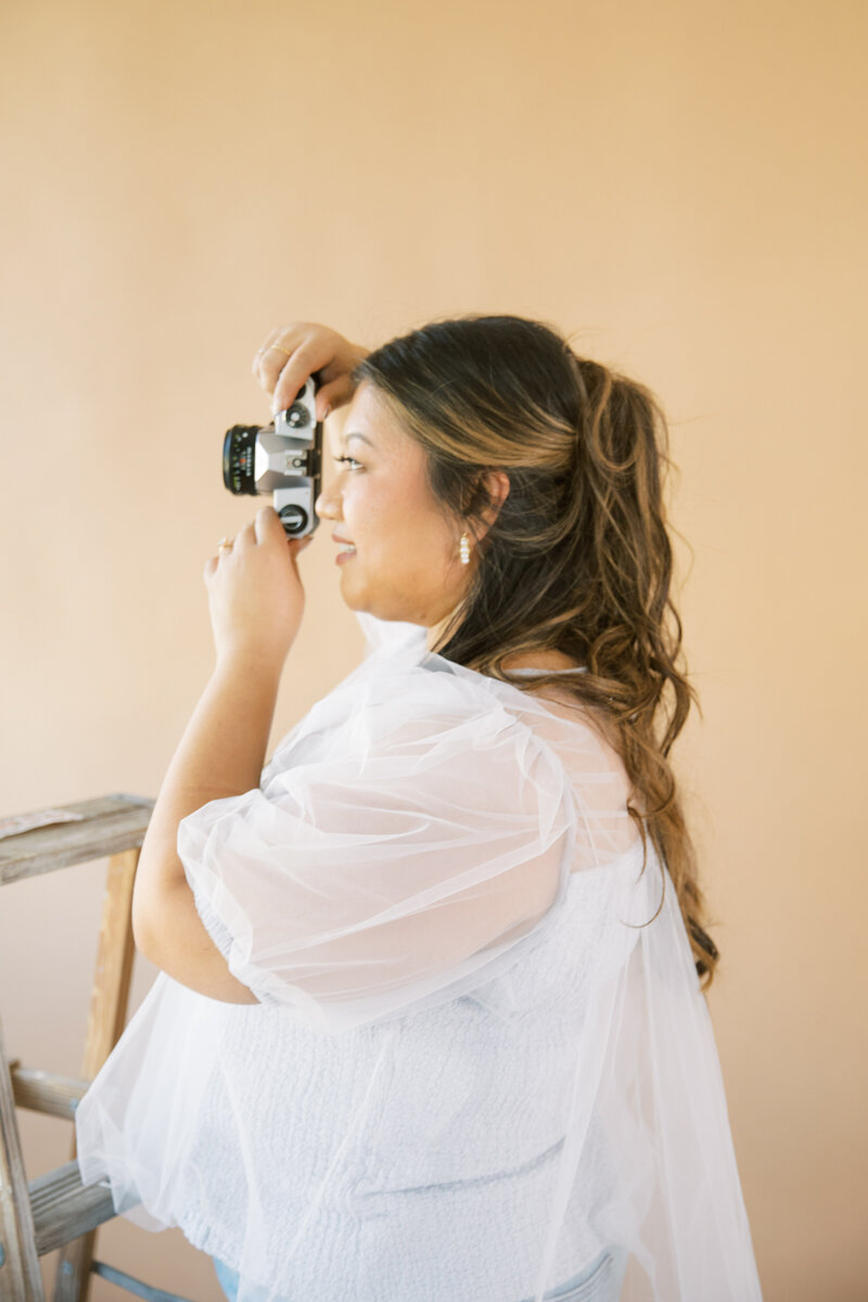 Monique Anne looking through a film camera