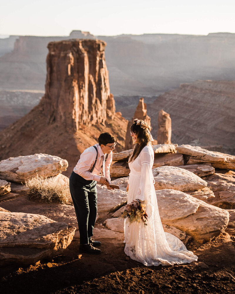 An eloping couple laughs as they say their vows in the Moab desert.