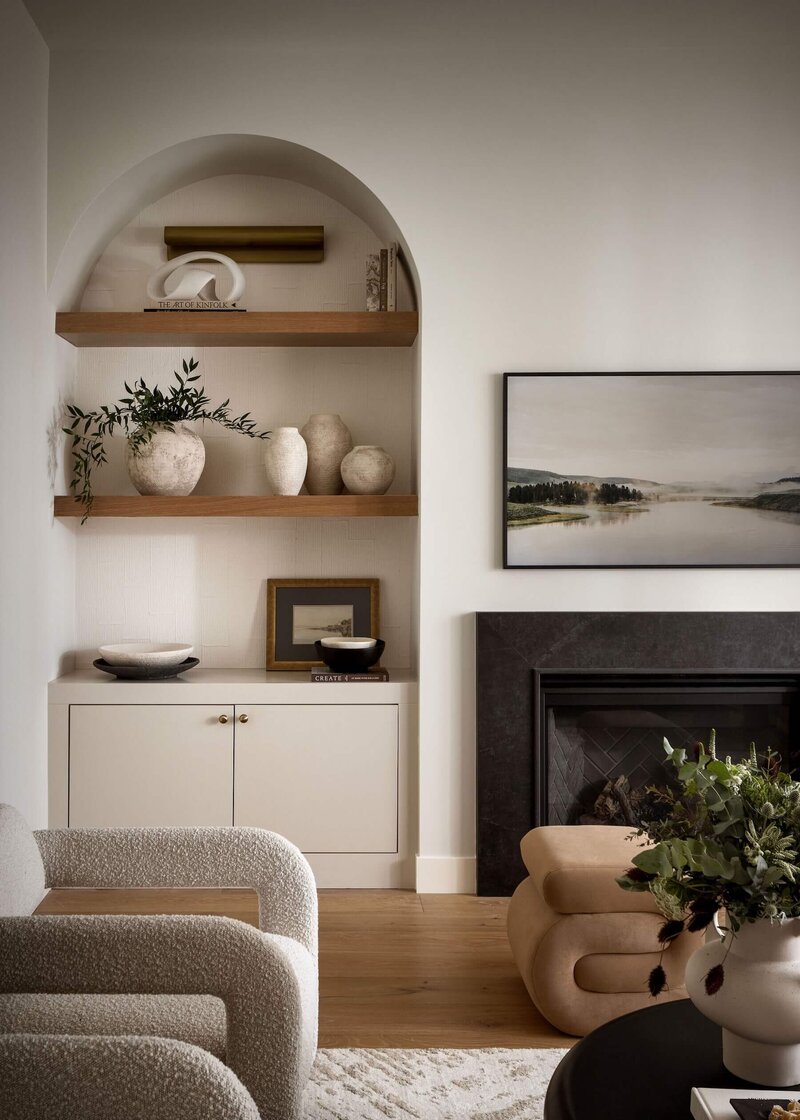 Arched build in shelves with natural cream cabinets with gold hardware. 