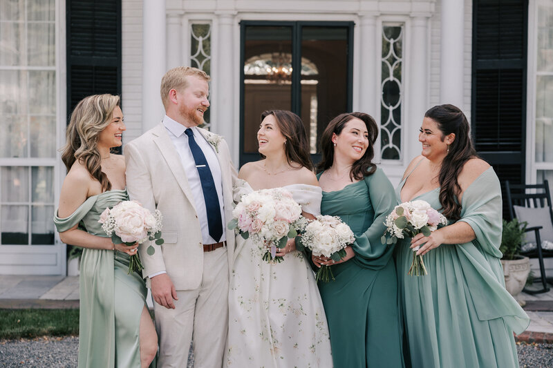 wedding party posing on golf course with smoke bombs