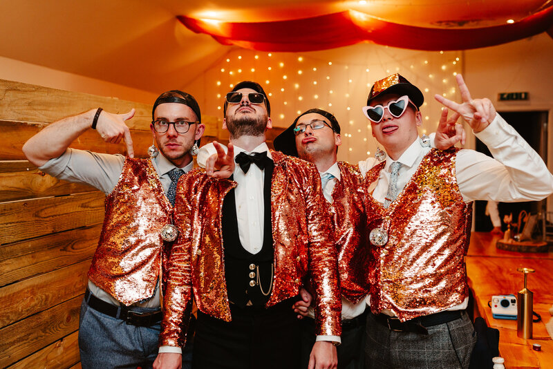 Groom and groomsmen wear sequin waistcoats and pose during alternative scotland wedding photography