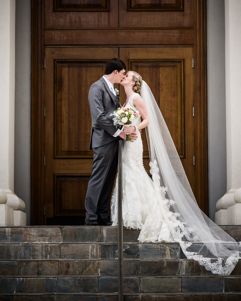 Bride and groom in front of large doors at Slavonian Lodge in Biloxi Mississippi