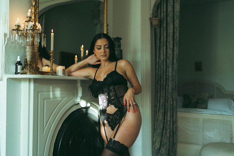 Woman posing in sun spot wearing black lingerie for boudoir photos shot by Elsie Goodman.