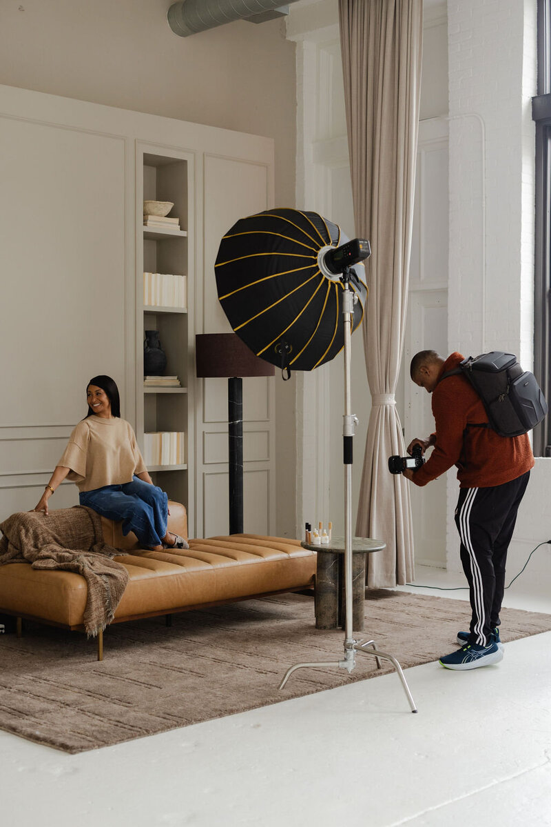 Two woman sitting on a couch in a studio rental in Chicago looking at their camera. 