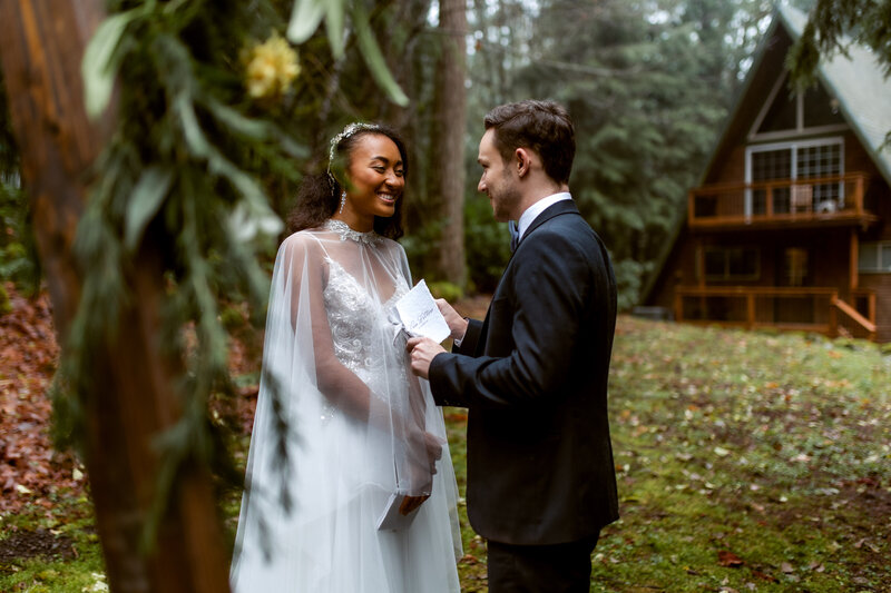 happy married couple in front of an A frame cabin Oregon Coast Elopement and Wedding Photographer