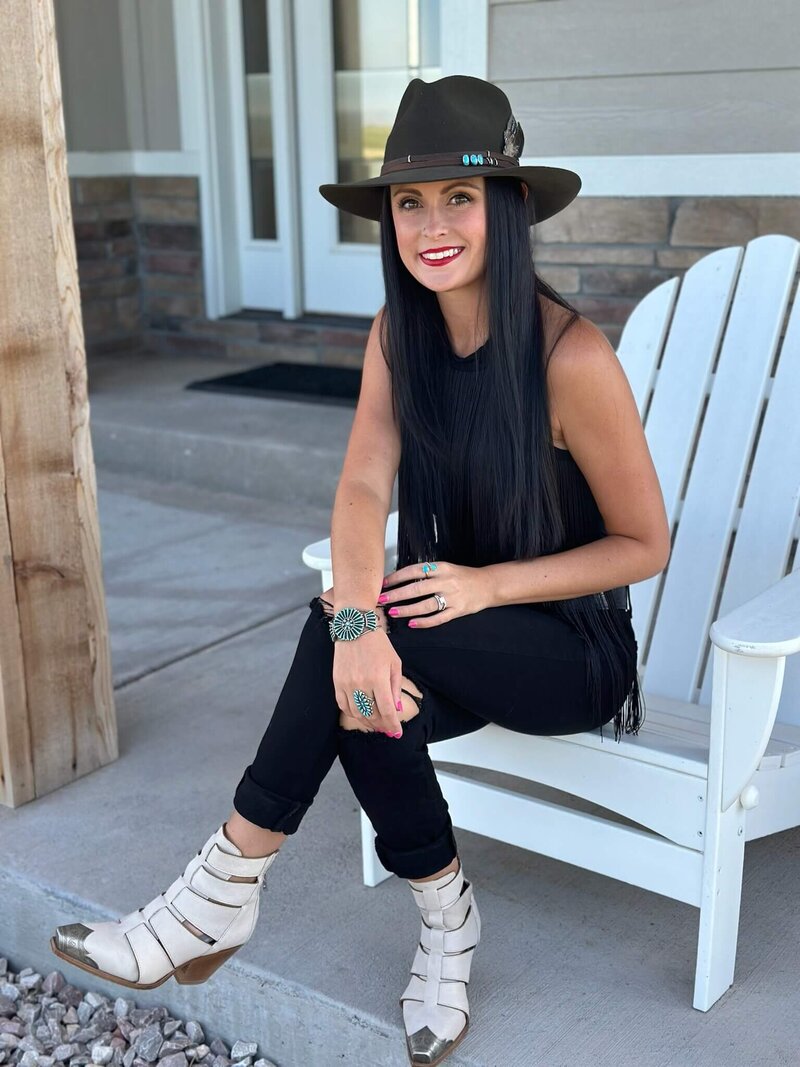 woman with dark hair in a western outfit with a hat