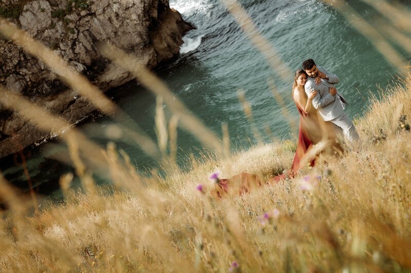 A romantic adventurous couple who decided to elope in the UK sharing a candid moment in front of Durdle Door in the south cost of England Dorset