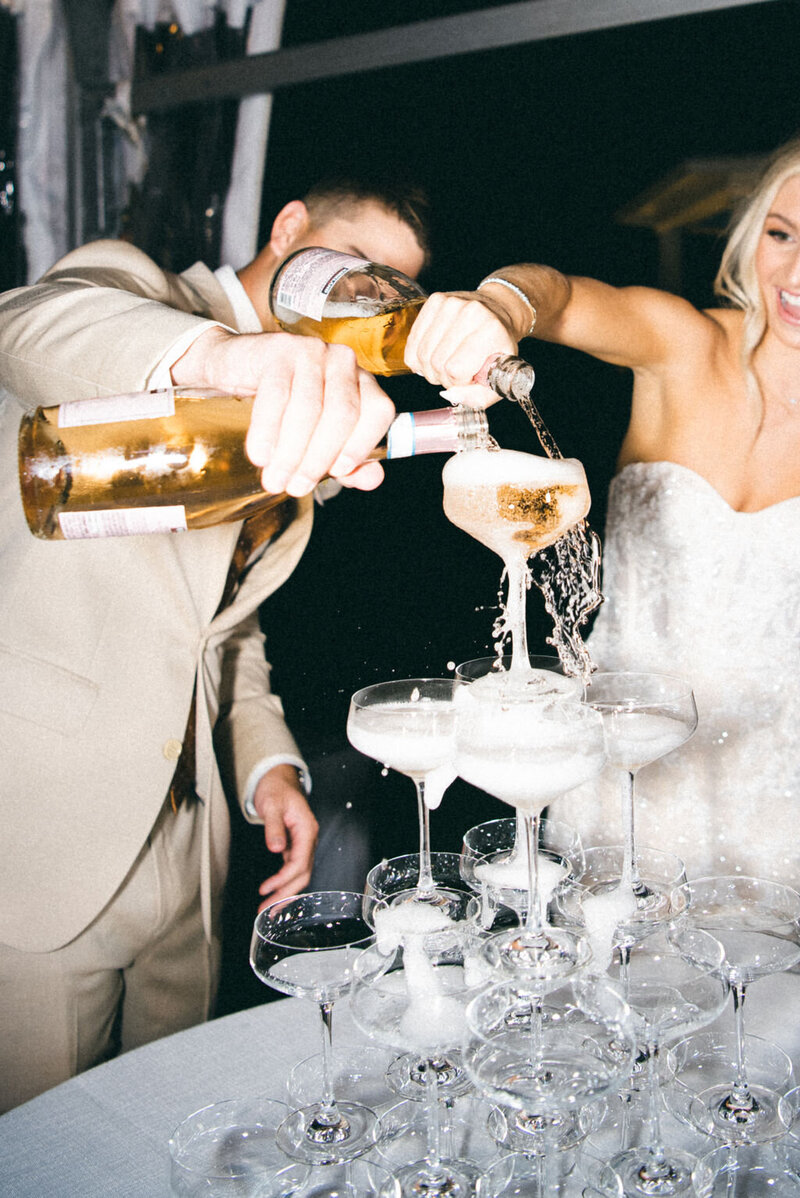 Bride and groom pour champagne tower