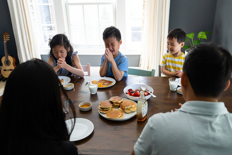 Family Saying Grace before pancake breakfast