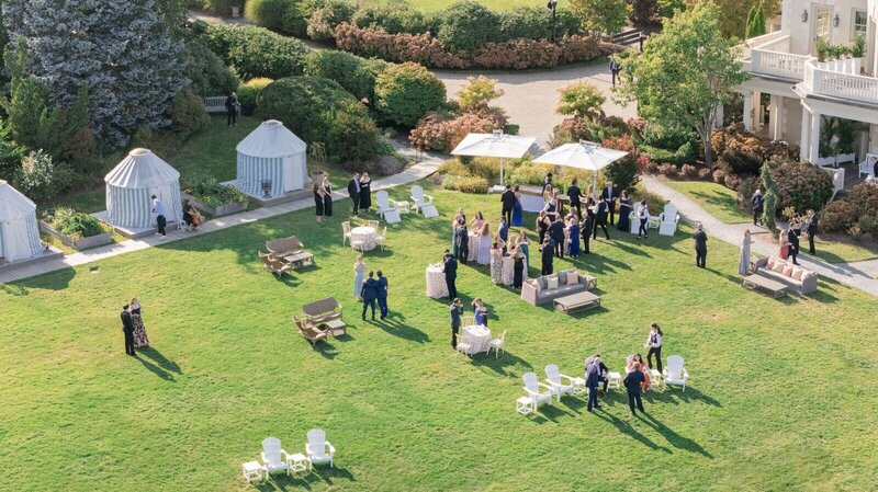 Wedding photographer captures a shot overlooking the outdoor wedding reception at an East Coast private estate