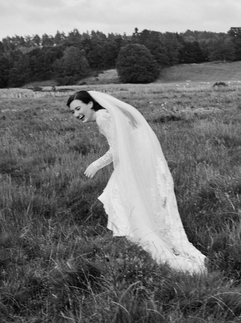 bride laughing in a field