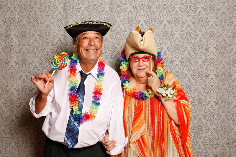 Couple in photobooth with silly hats and leis