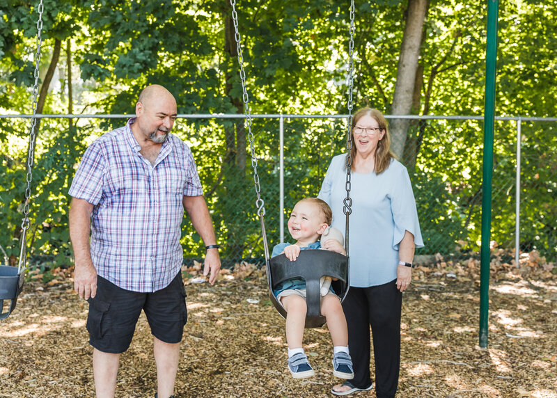 Grandparents and grandchild playing in a NJ park.