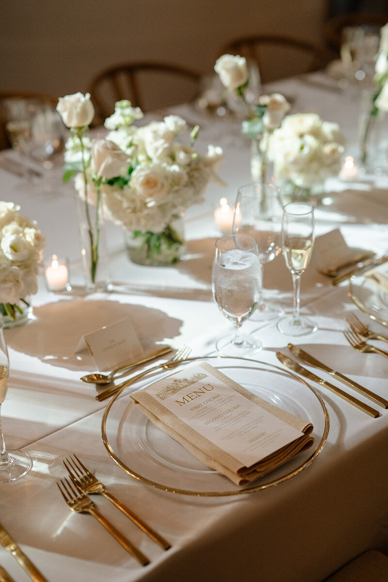White florals and glassware on a reception table