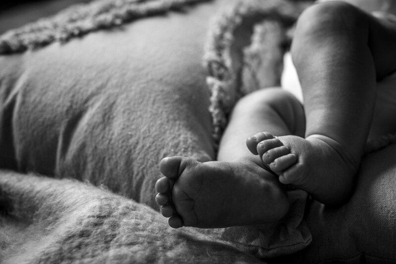 Detailfoto van babyvoetjes in die van moeder tijdens fotoshoot in Spijkenisse