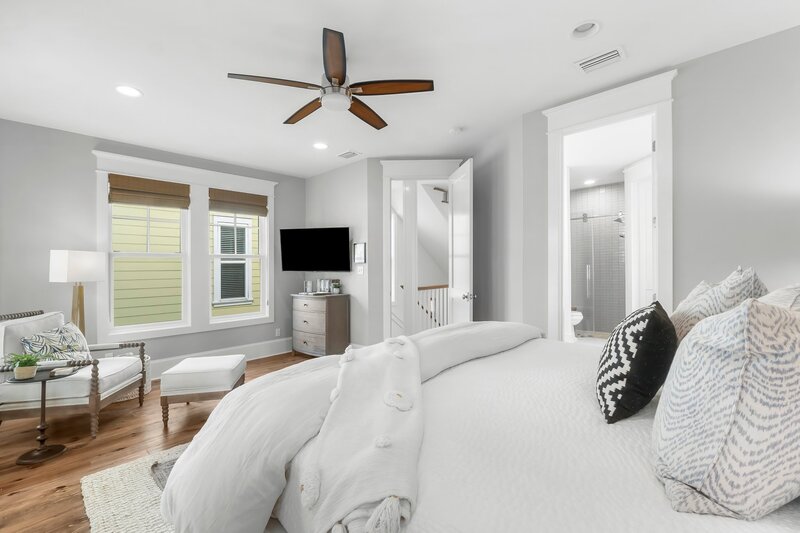 King suite featuring sitting area, smart TV, and access to full ensuite bath in a luxury Carillon Beach home.
