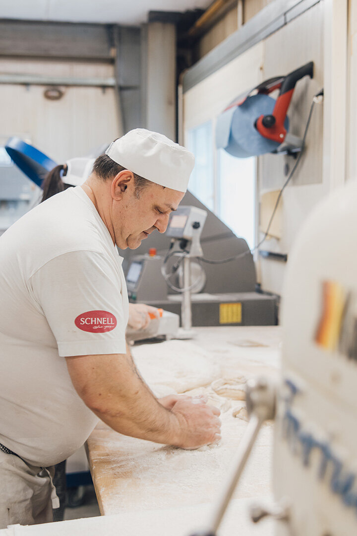 Bäcker knetet Brotteig in der Backstube der Bäckerei Schnell in Feldkirch