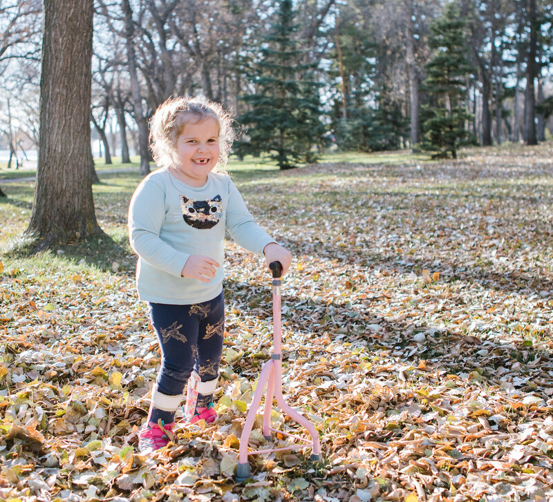 Child with mobility issues using a walking cane in the park, gaining independence with a supportive aid