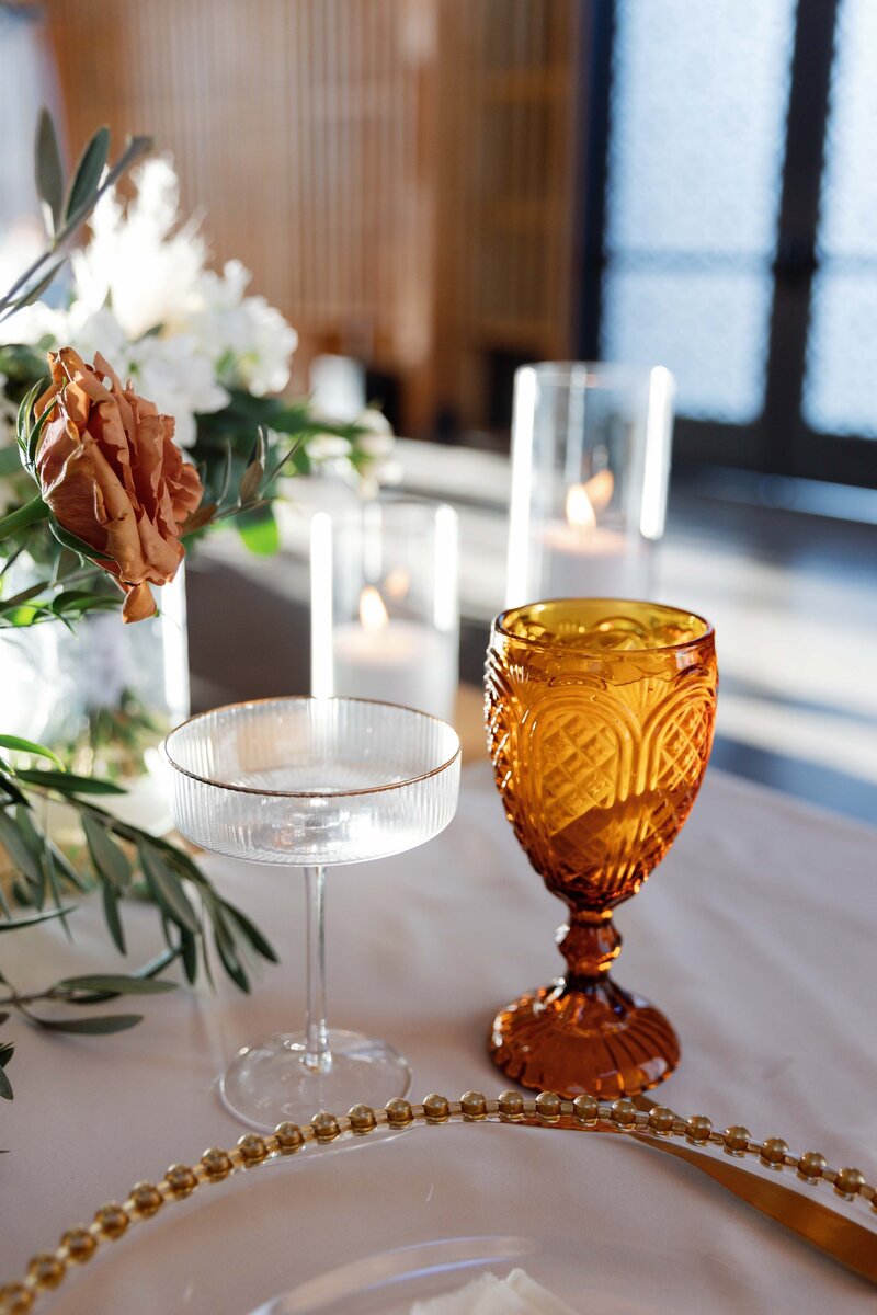 Two cocktail glasses at sweetheart table at wedding reception.