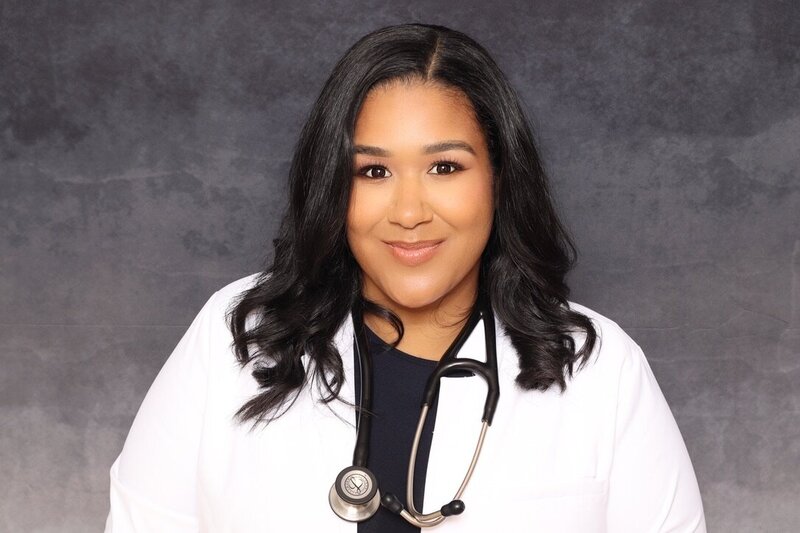 Female doctor wearing a white coat with stethoscope posing for a professional headshot at AR Photobooth.