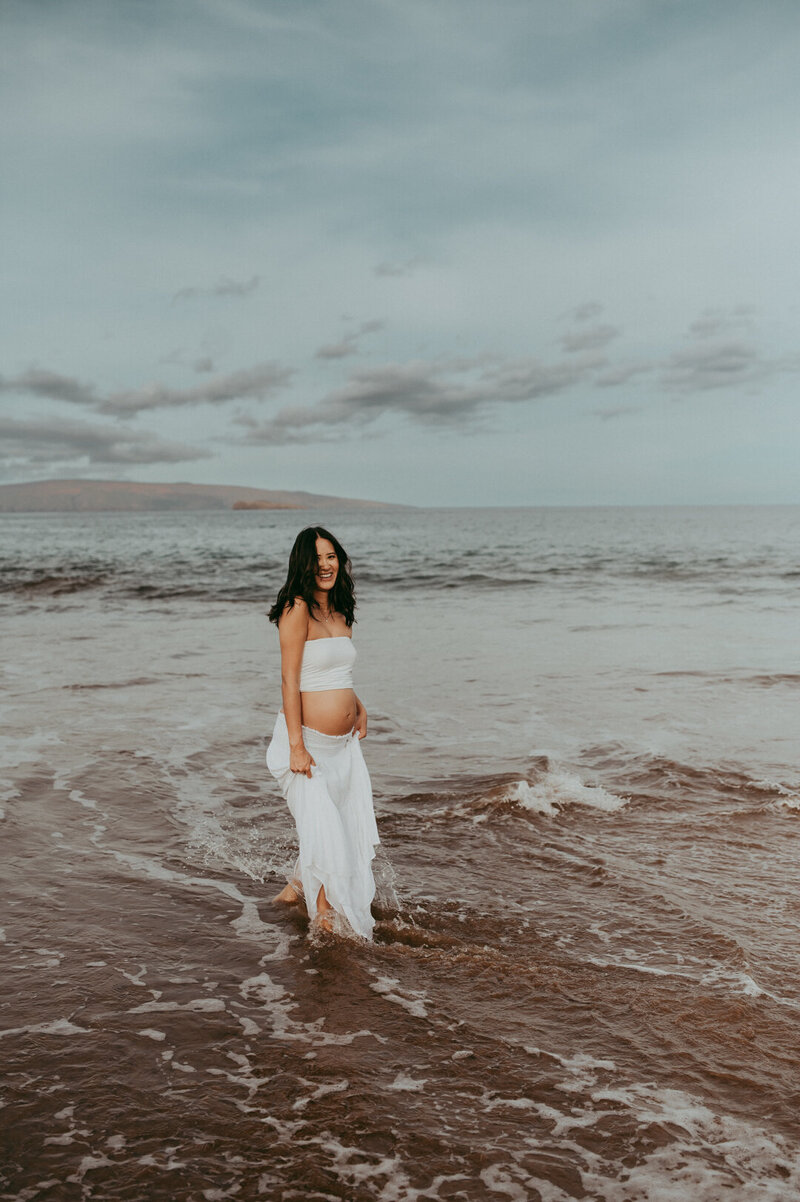 couple being photographed in a field of flowers by Portland maternity photographer
