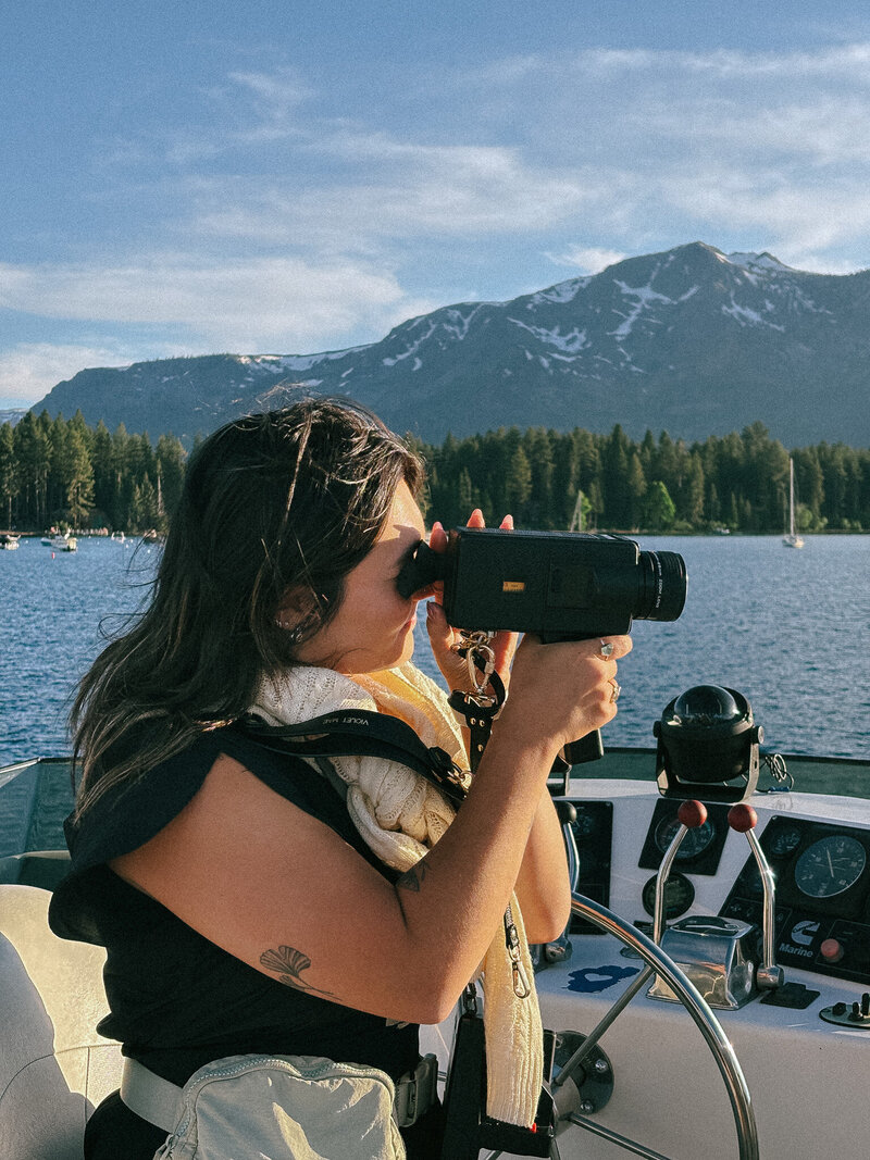 young super 8 film photographer, destination wedding photographer sitting next to multiple wedding photographs