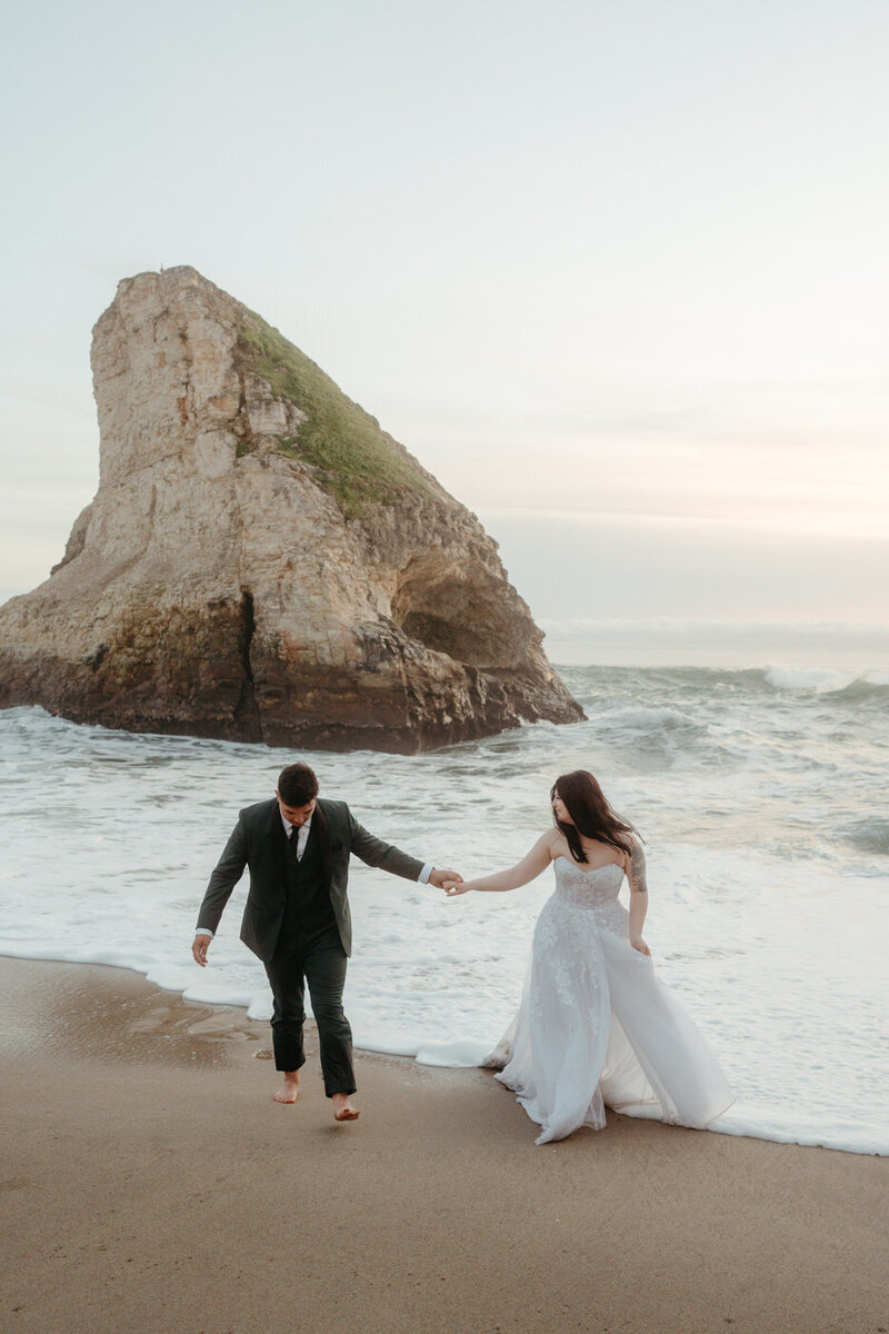 Wedding Couple splashes in the water for their Shark Fin Cove Wedding