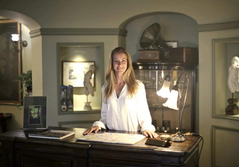 Smiling woman standing behind reception desk as part of Nova Lux DR’s skill-building workshop