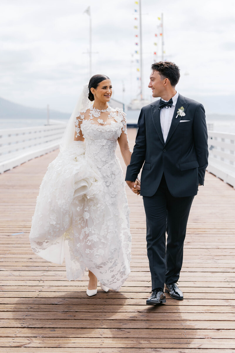 Wedding Photographer for the Bay Area, bride and groom walking together away from camera under strings of lights