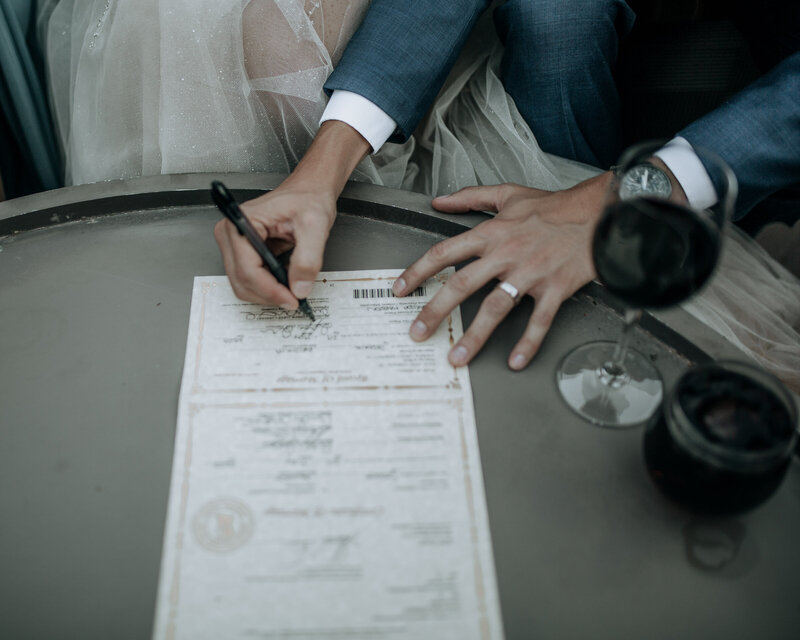 groom signing marriage license at enchantment resort with wine