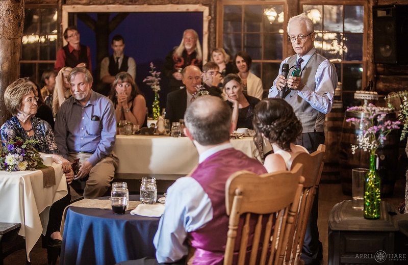 Wedding reception toasts inside a summer camp wedding in Boulder Colorado at Colorado Mountain Ranch