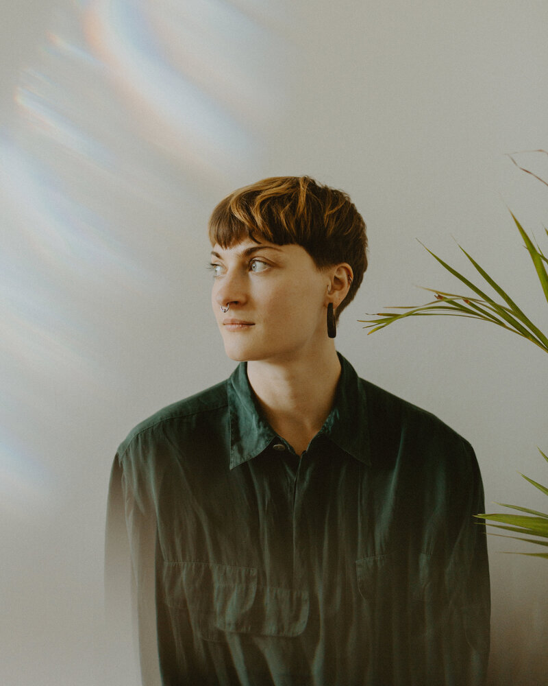 Portrait of a woman looking to left against a white wall