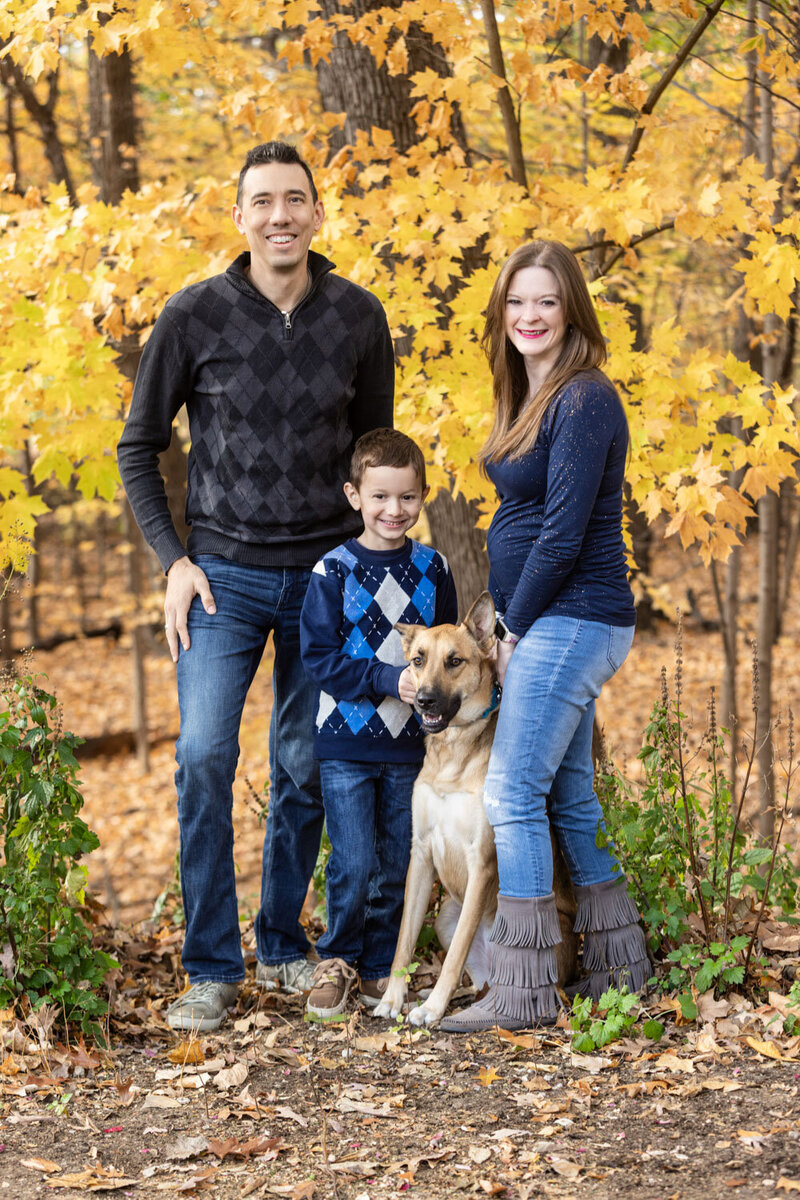 Family of three with their dog in an outdoor setting for a family portrait