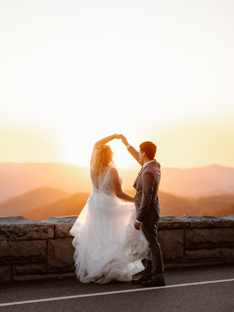 photographers in gatlinburg tn photographs bride and groom dancing on the foothills parkway in the smoky mountains at sunset for their gatlinburg elopement 