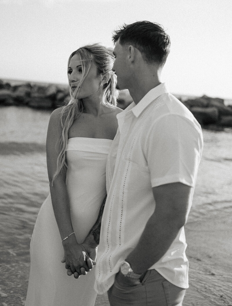 engaged couple at the beach looking at the water