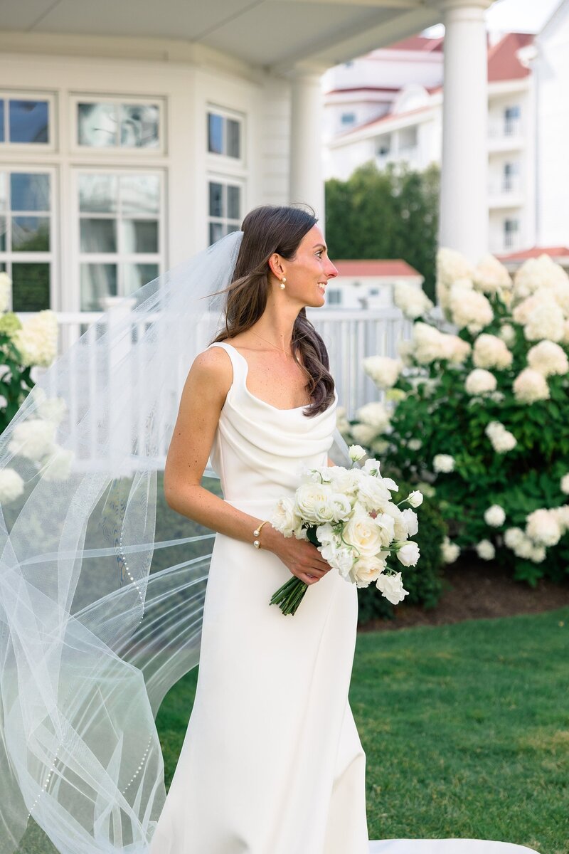 Bride looking into the distance holding bouquet and hydrangeas 
