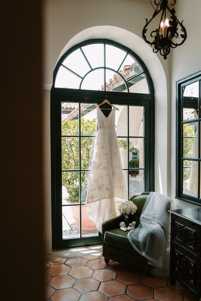 wedding gown hanging in window