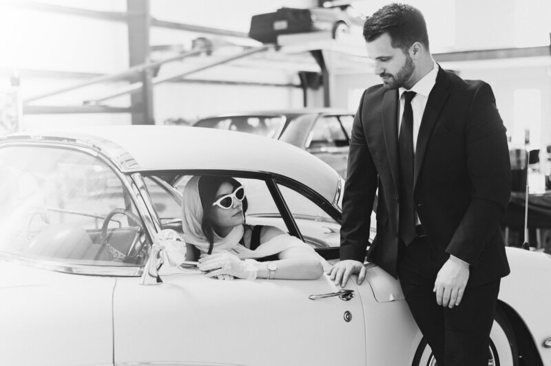 black and white vintage photo of man and woman in a vintage corvette