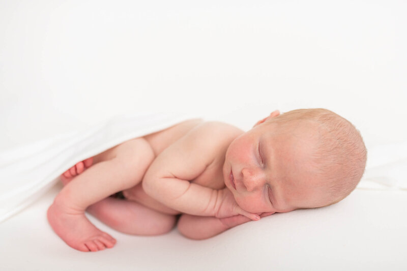 newborn boy in white sleeping