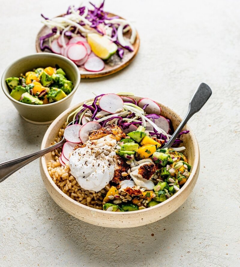 Spicy Burrito Menopause Abundance Bowl™ filled with brown rice, grilled protein, crunchy radish and cabbage, avocado salsa and yoghurt. Vibrant and balanced for midlife nourishment.