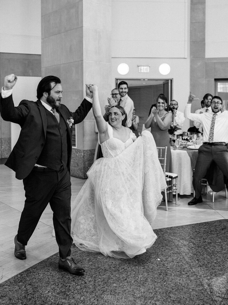 Bride and groom walk happy to their wedding reception 
