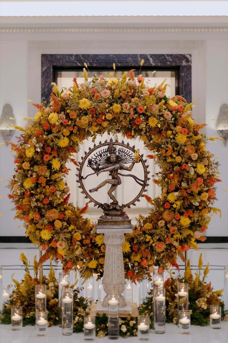 A beautiful foyer display for a hindu wedding with orange and yellow flowers